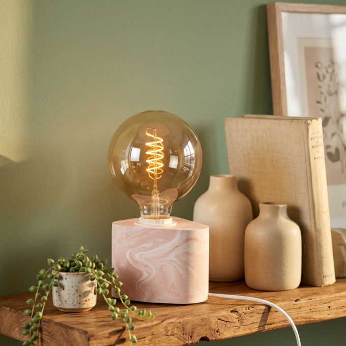 Lampada " Jesmonite " già pronta con lampadina accesa, disposta su una mensola — crea la tua lampada " Jesmonite " con il kit fai da te